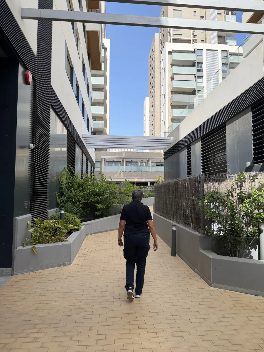 Operario realizando una ronda por un pasaje entre edificios modernos