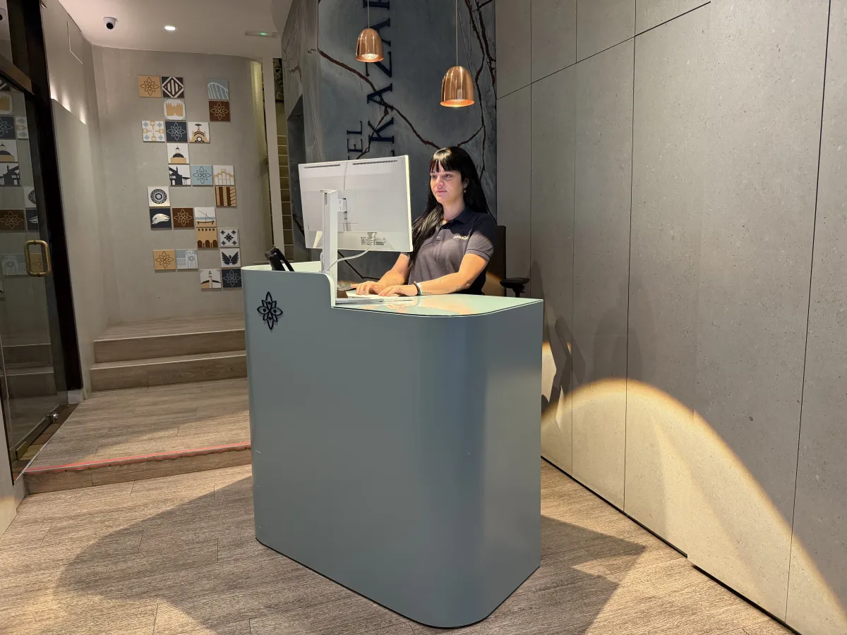 Recepcionista atendiendo en el mostrador de recepción